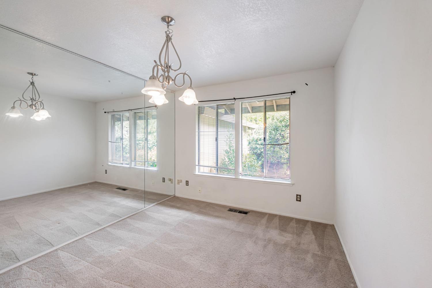 7822 Tamara Drive Fair Oaks, CA 95628 - Photo 18 of 28 en empty room with windows and chandelier