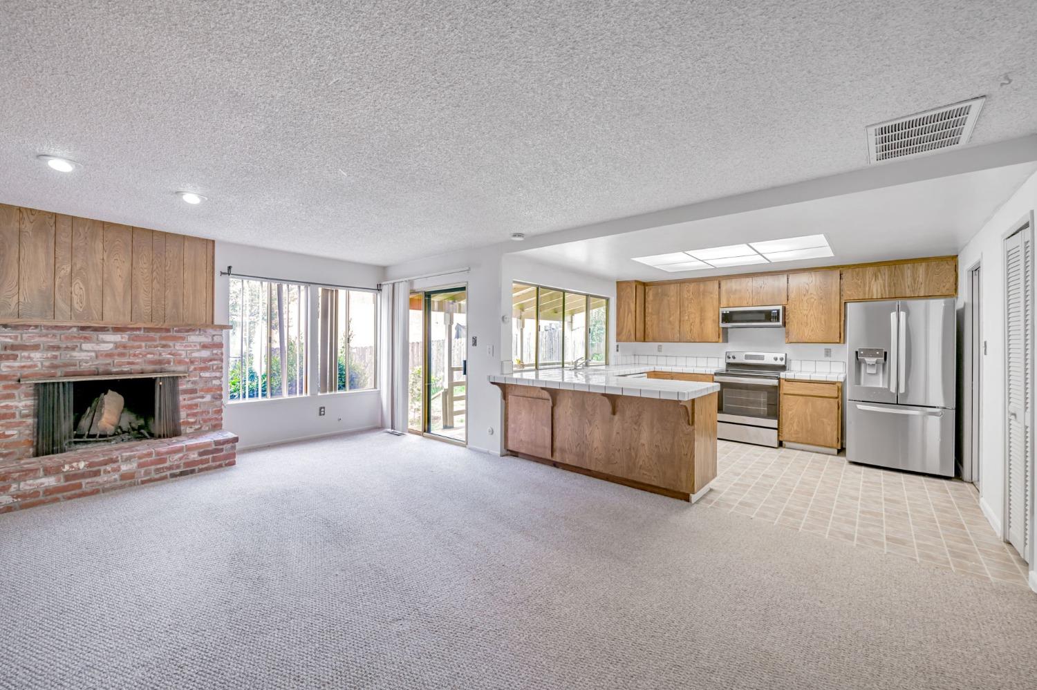 7822 Tamara Drive Fair Oaks, CA 95628 - Photo 2 of 28 a large living room with a fireplace and a large window
