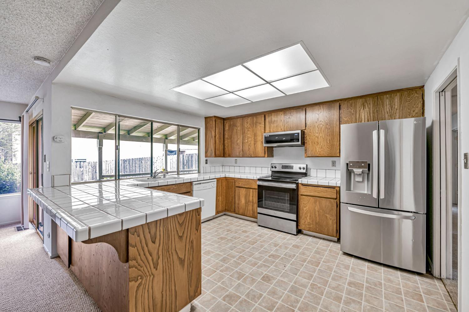 7822 Tamara Drive Fair Oaks, CA 95628 - Photo 4 of 28 a kitchen with granite countertop a refrigerator a sink a stove and island