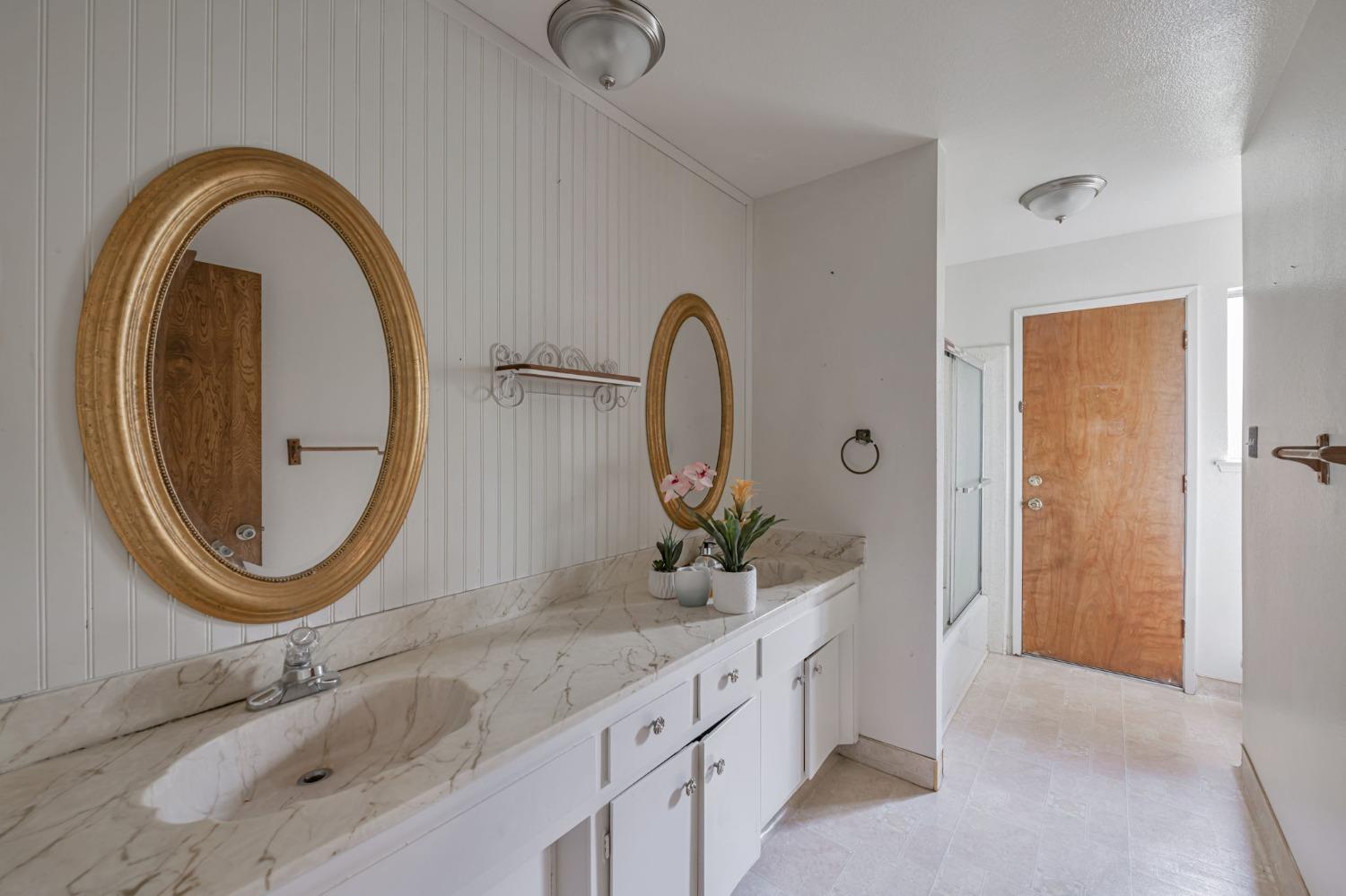 7822 Tamara Drive Fair Oaks, CA 95628 - Photo 10 of 28 a bathroom with a granite countertop sink and a mirror