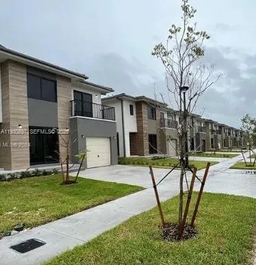 a view of a house with backyard and a tree