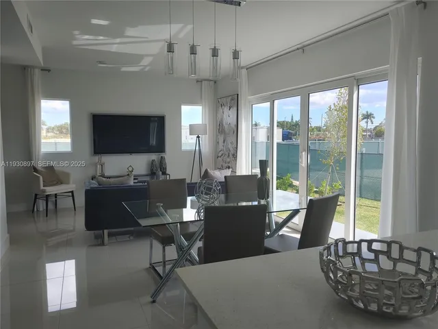 a living room with furniture a flat screen tv and a large window