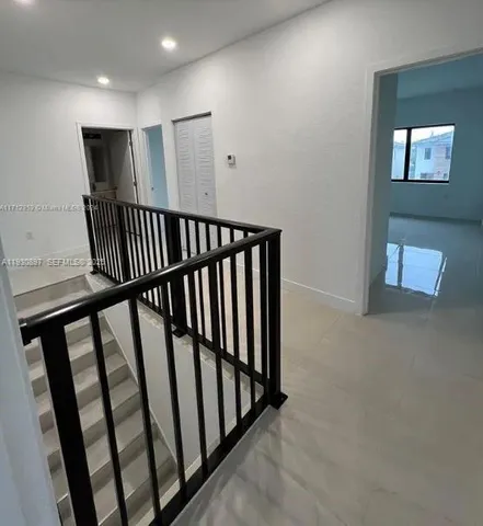 a view of staircase with railing and white walls