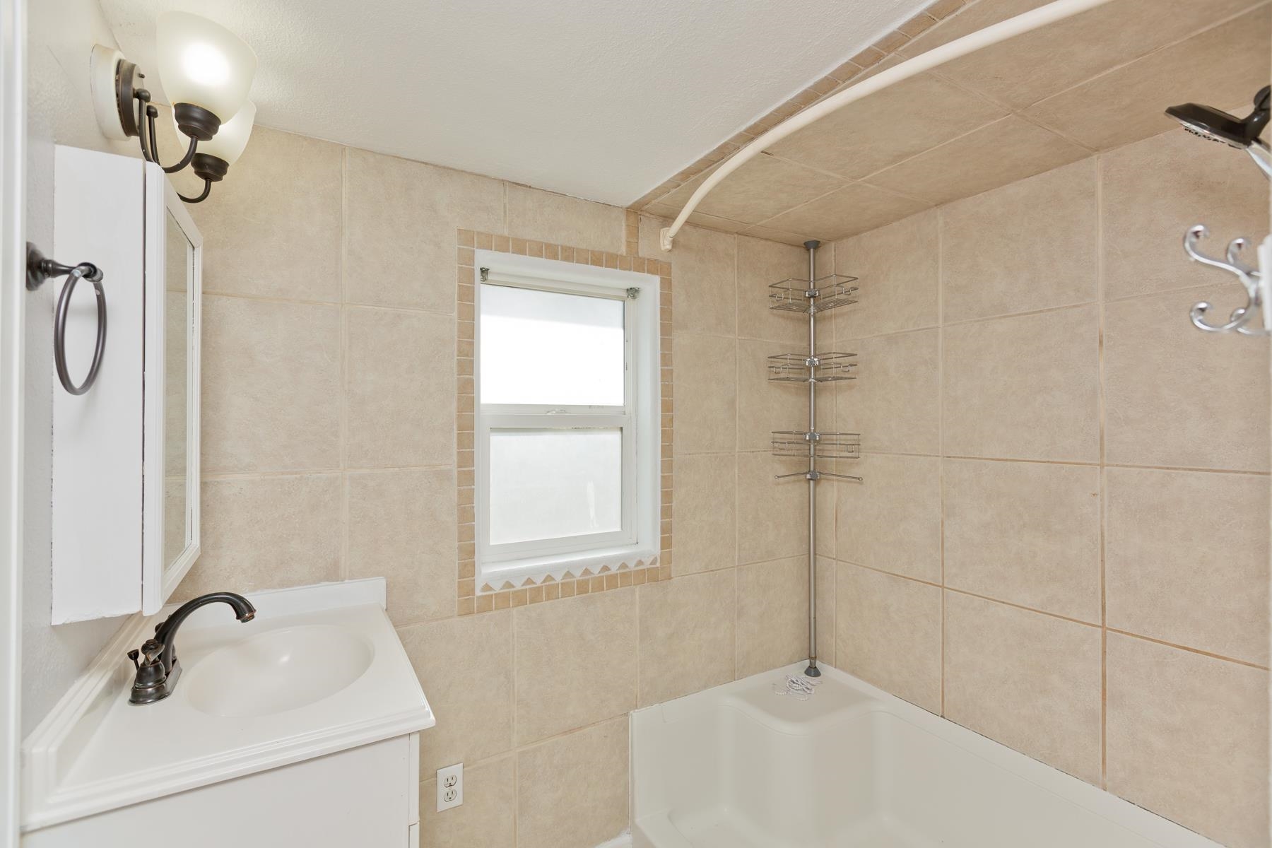 431 Pleasant Ridge Lane, Unit B Grand Junction, CO 81507 - Photo 17 of 20 a bathroom with a sink a window and shower