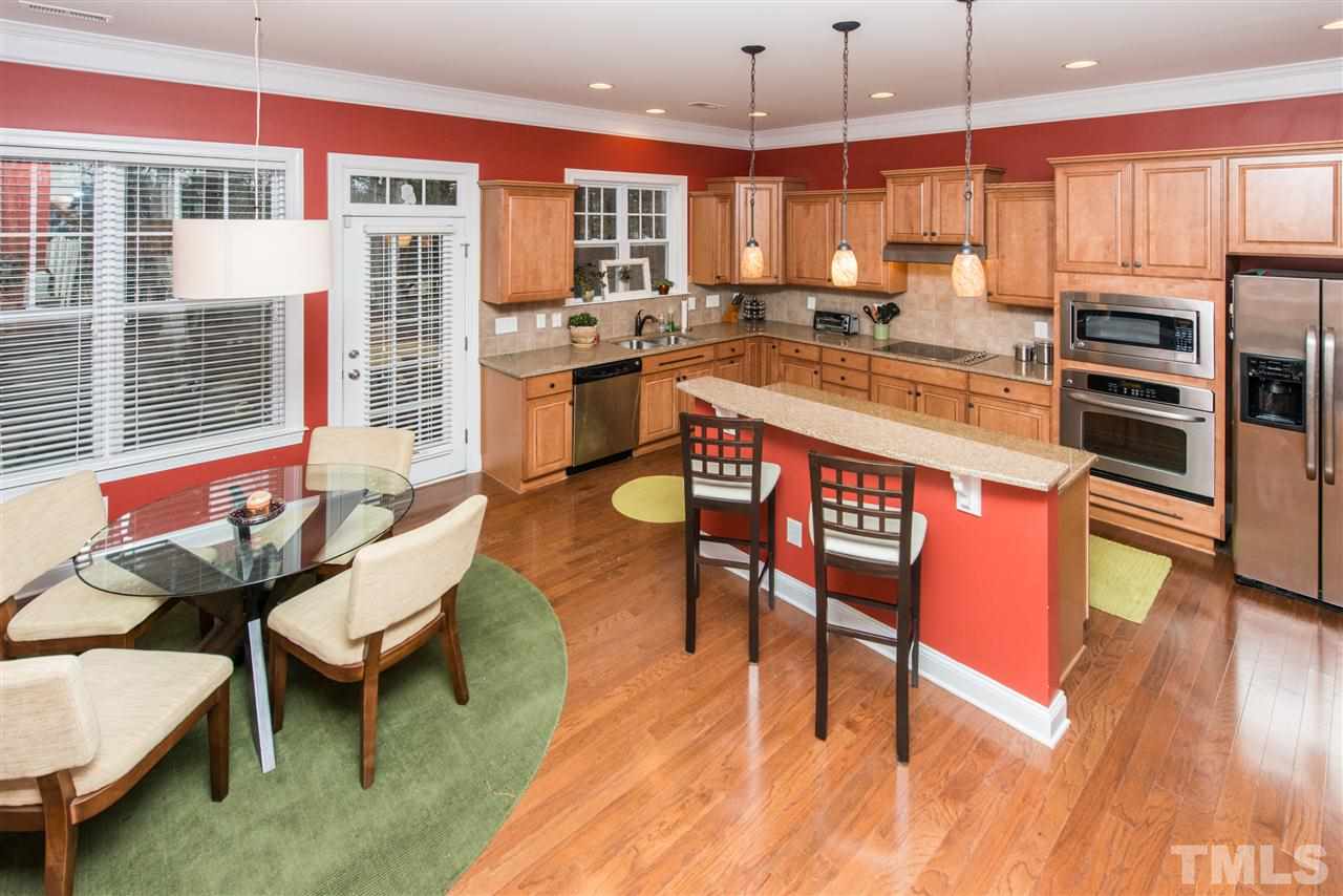 924 Chapanoke Road Raleigh, NC 27603 - Photo 6 of 20 a dining hall with stainless steel appliances kitchen island granite countertop a stove a kitchen island a dining table and chairs
