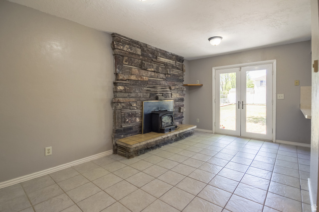 634 South 2100th Street West Vernal, UT 84078 - Photo 21 of 71 Stone-clad fireplace with a wood-burning stove and a tiled hearth