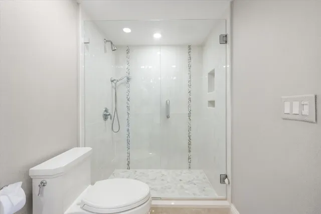 a bathroom with a toilet a sink and shower