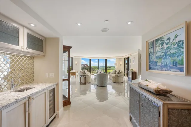 a large white kitchen with a large window and stainless steel appliances