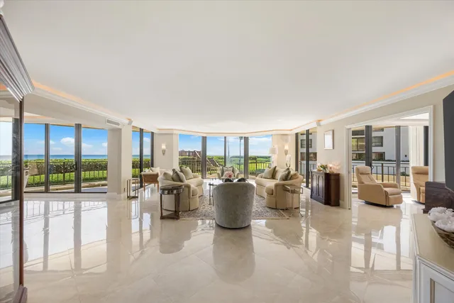 a living room with furniture and floor to ceiling windows