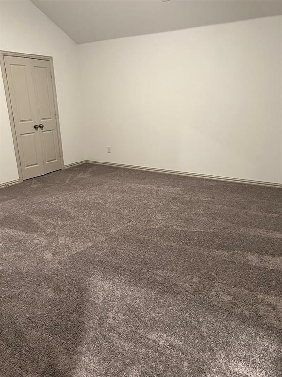 6041 Roper Road McKinney, TX 75070 - Photo 22 of 24 Spacious room featuring vaulted ceilings, light-toned walls, and a neutral carpet