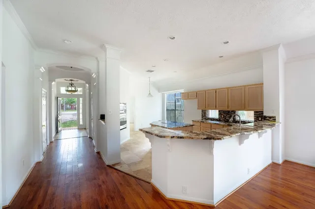 a kitchen with stainless steel appliances granite countertop a sink stove and wooden floor