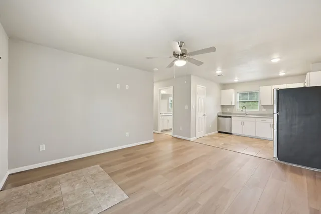 wooden floor in an empty room with a kitchen
