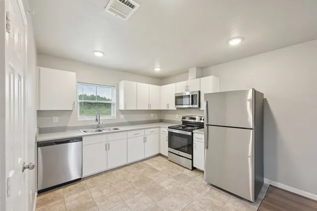 a kitchen with a sink stainless steel appliances and counter space