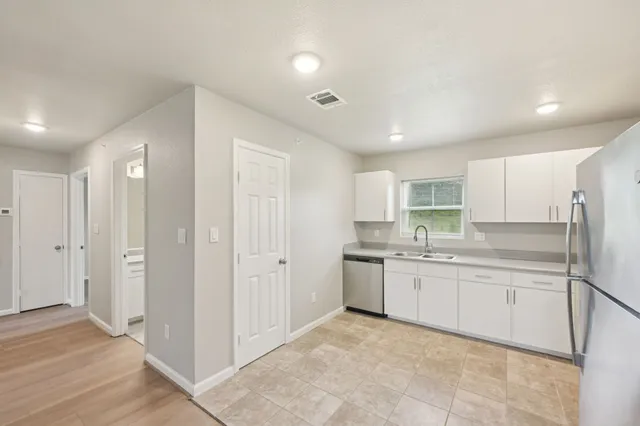 a large white kitchen with a sink