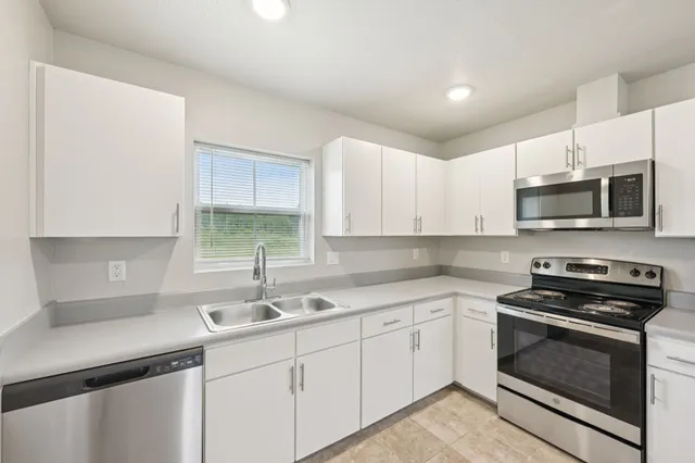 a kitchen with sink a microwave and cabinets