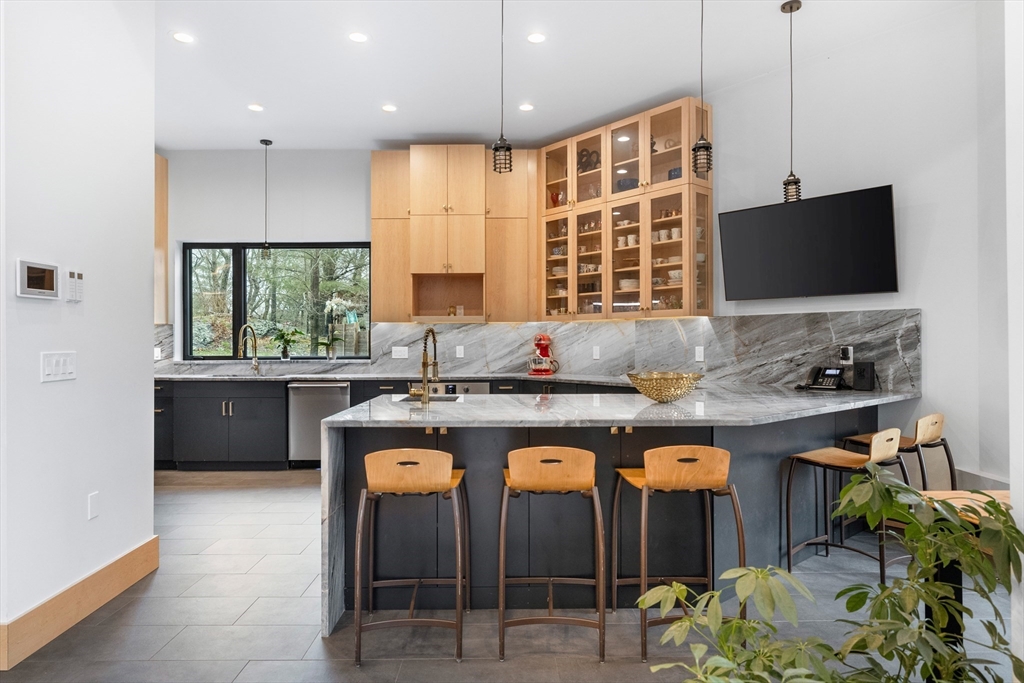 71 Grove Street Brookline, MA 02467 - Photo 19 of 42 a kitchen with kitchen island granite countertop a sink and a stove
