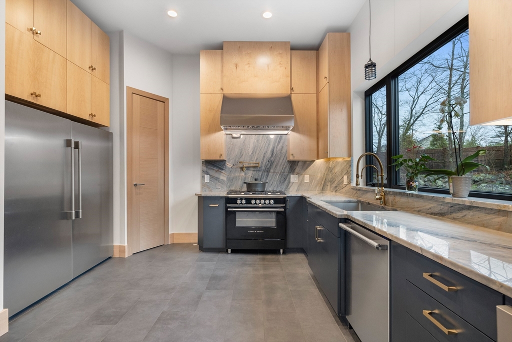 71 Grove Street Brookline, MA 02467 - Photo 22 of 42 a kitchen with stainless steel appliances granite countertop a stove and a refrigerator