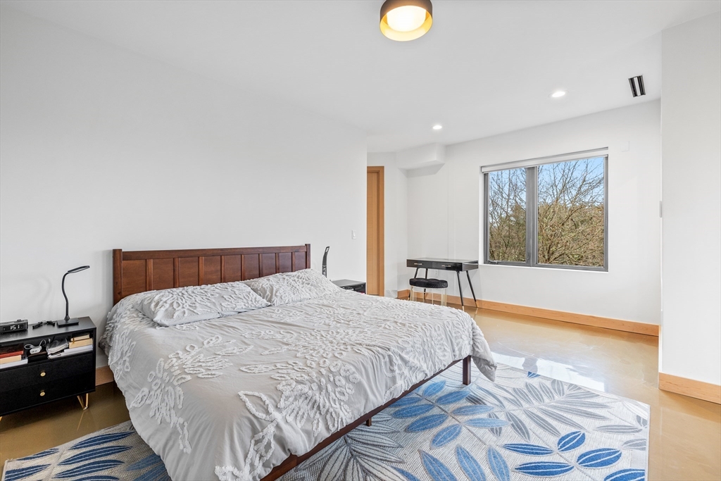 71 Grove Street Brookline, MA 02467 - Photo 23 of 42 a bed sitting in a bedroom next to a window