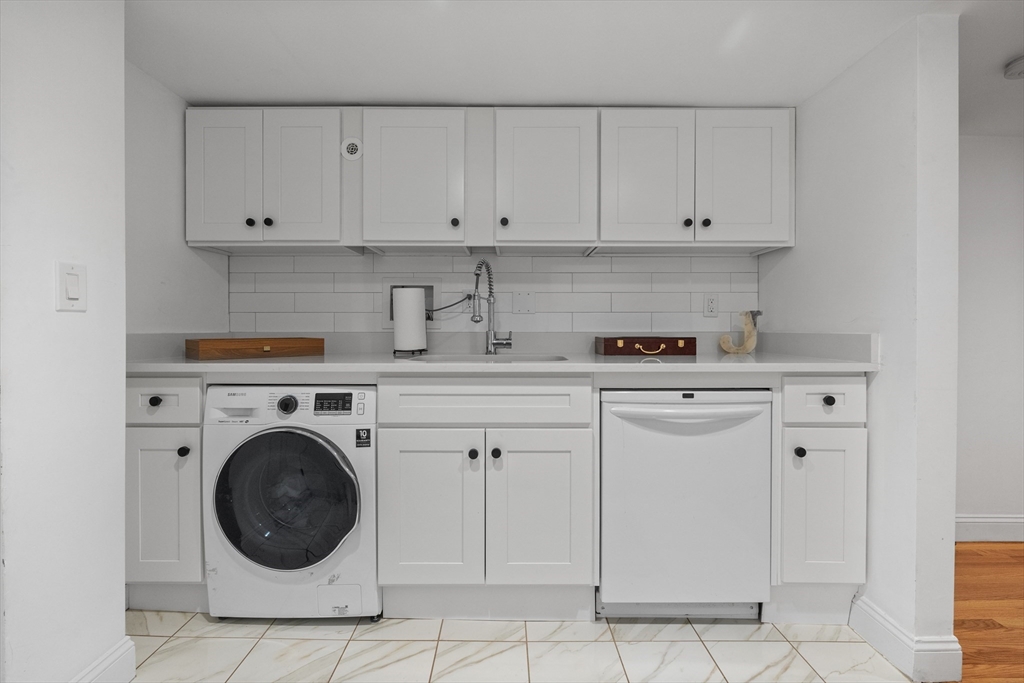 71 Grove Street Brookline, MA 02467 - Photo 39 of 42 a view of cabinets and washer in it