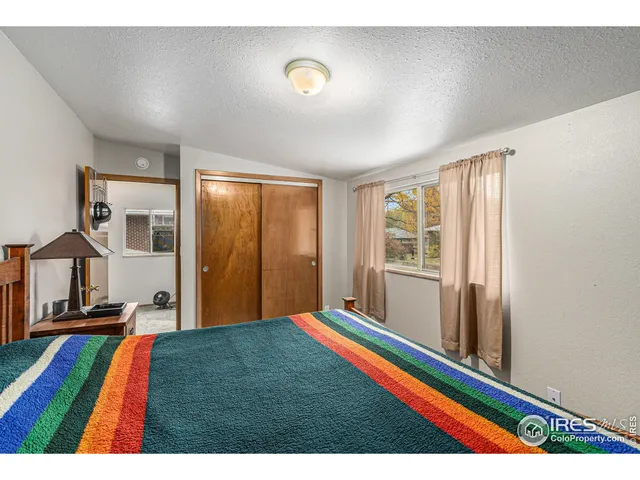 a living room with a bed furniture and a large window