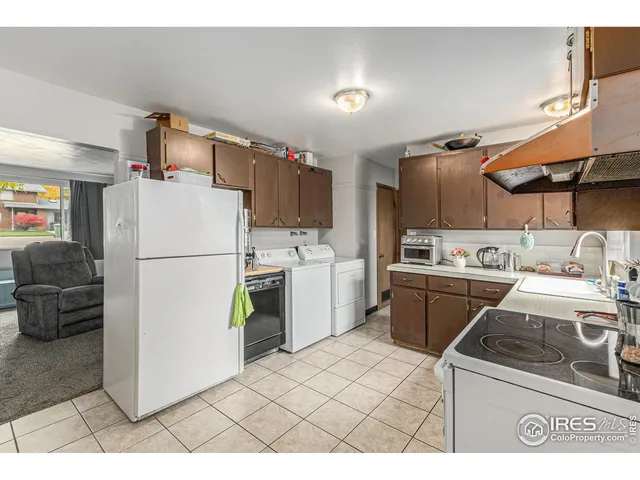 a kitchen with a refrigerator a stove top oven a sink and cabinets