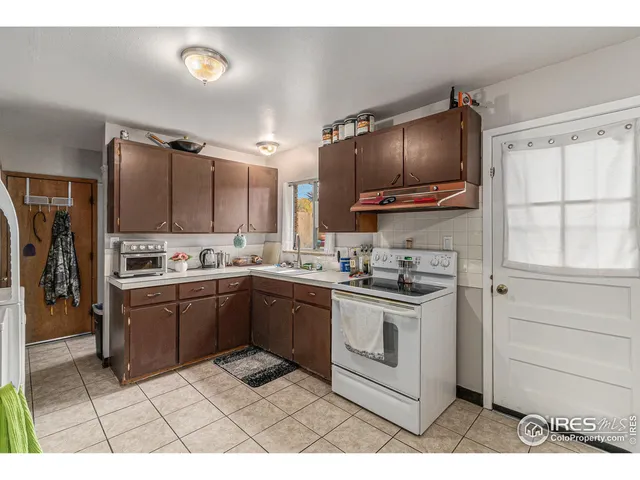 a kitchen with granite countertop a stove top oven and cabinets