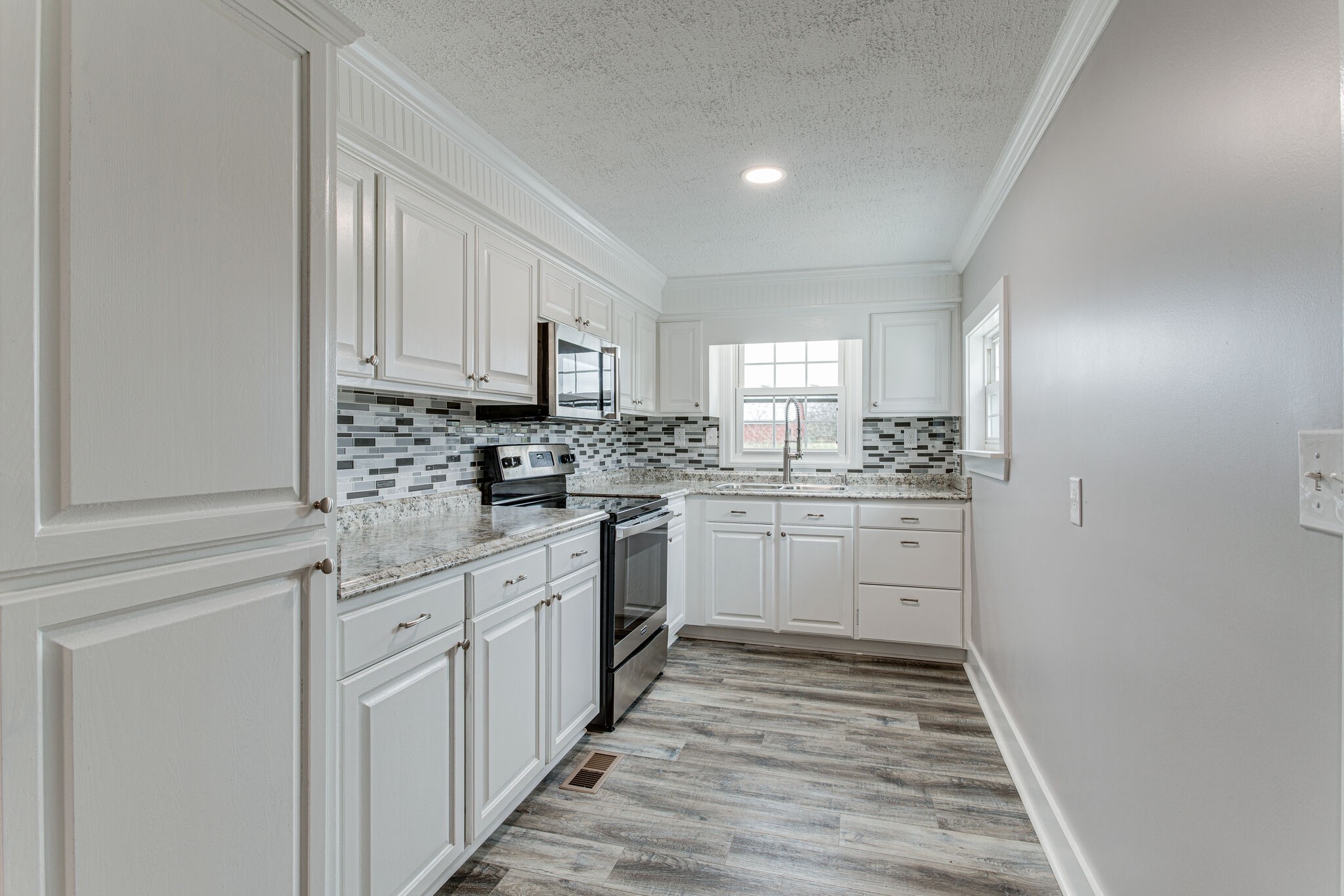 1466 Bible Crossing Road Winchester, TN 37398 - Photo 14 of 31 a kitchen with granite countertop white cabinets and white appliances