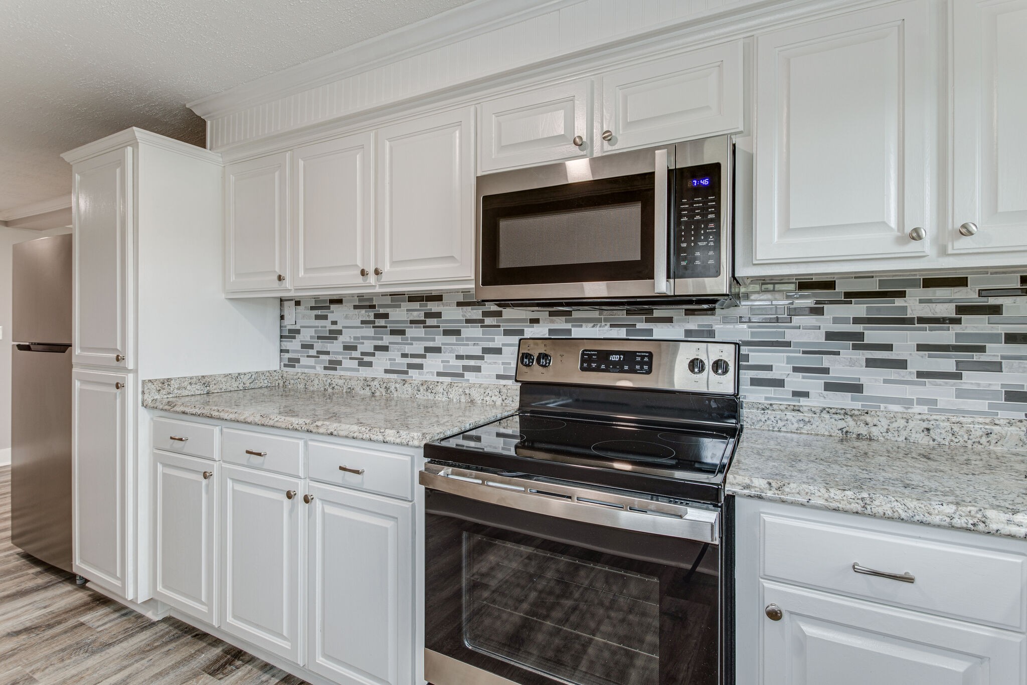 1466 Bible Crossing Road Winchester, TN 37398 - Photo 17 of 31 a kitchen with stainless steel appliances granite countertop a stove microwave and cabinets