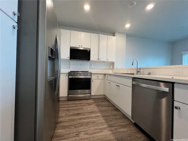 a kitchen with a sink a microwave and cabinets