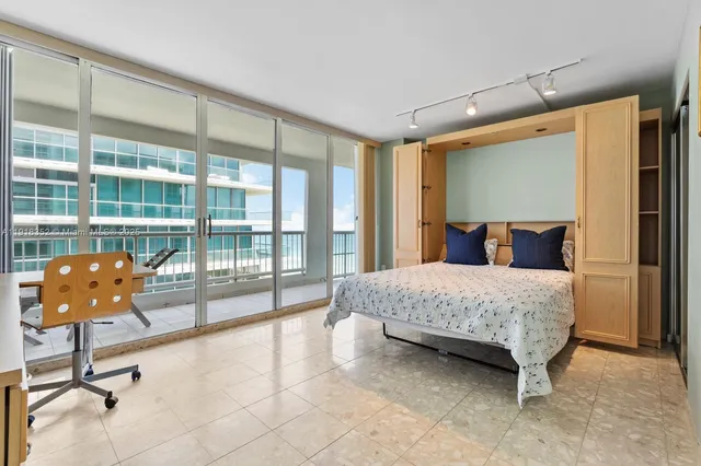 a bedroom with a bed and glass door