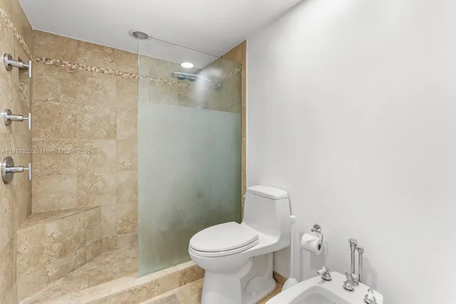 a bathroom with a toilet and a shower