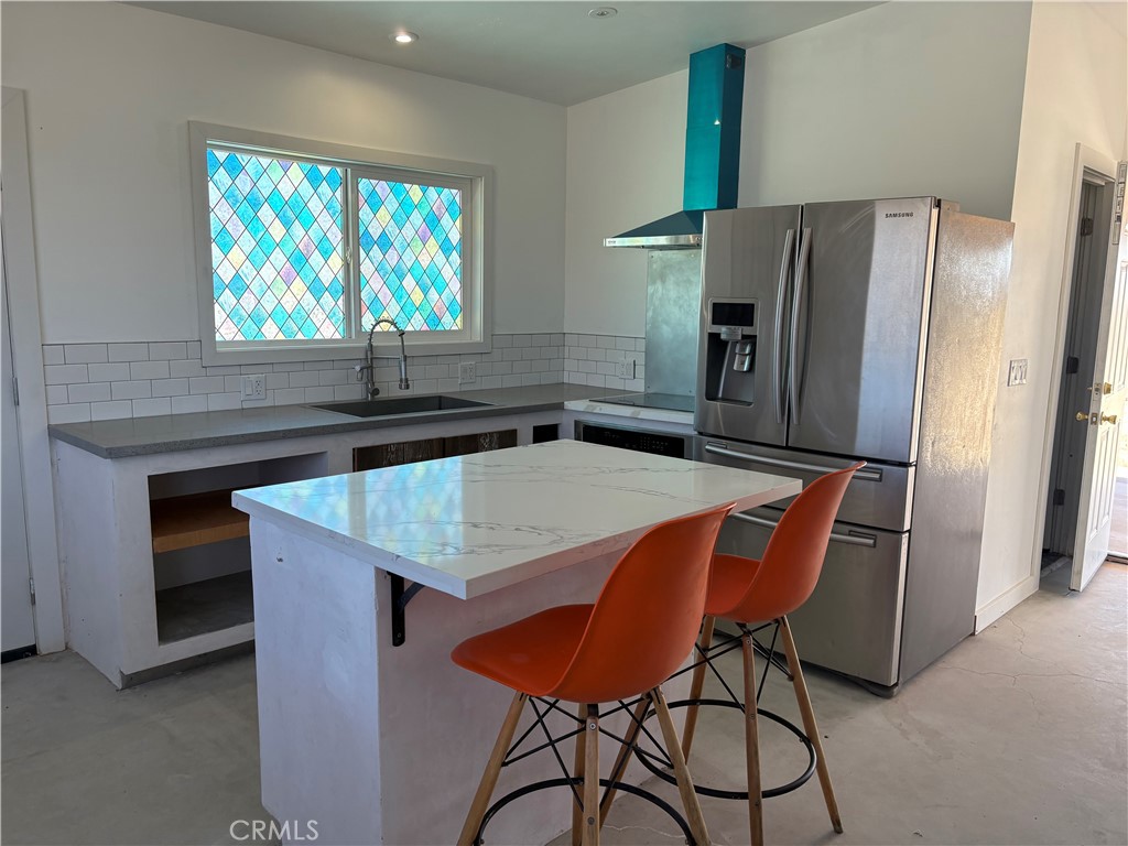 86515 Amboy Road Twentynine Palms, CA 92277 - Photo 7 of 34 a kitchen with stainless steel appliances granite countertop a table chairs refrigerator and a sink
