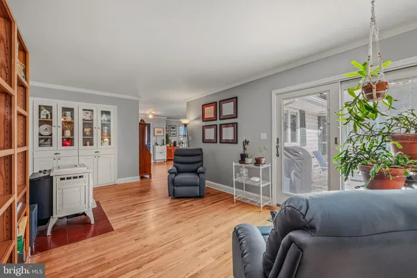 a living room with furniture a bookshelf and a wooden floor