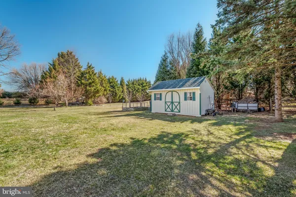 a view of a house with large tree and wooden fence