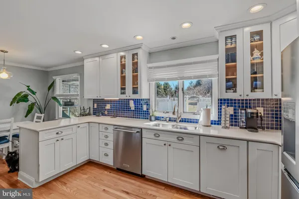 a kitchen with a sink dishwasher cabinets and white appliances