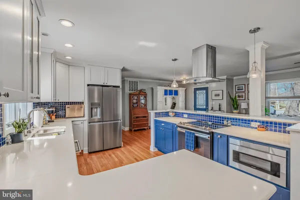 a kitchen with stainless steel appliances granite countertop a refrigerator a stove and a sink