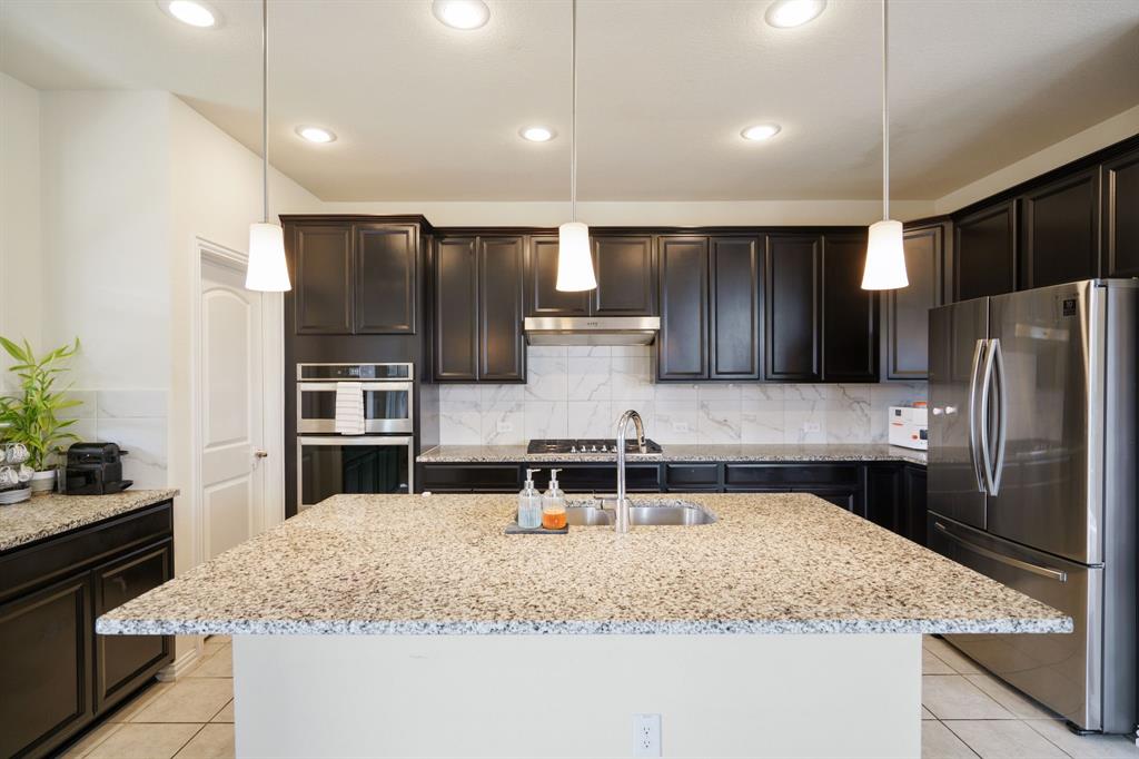 6049 Iron Creek Road Fort Worth, TX 76137 - Photo 11 of 30 a kitchen with stainless steel appliances granite countertop a sink refrigerator and cabinets