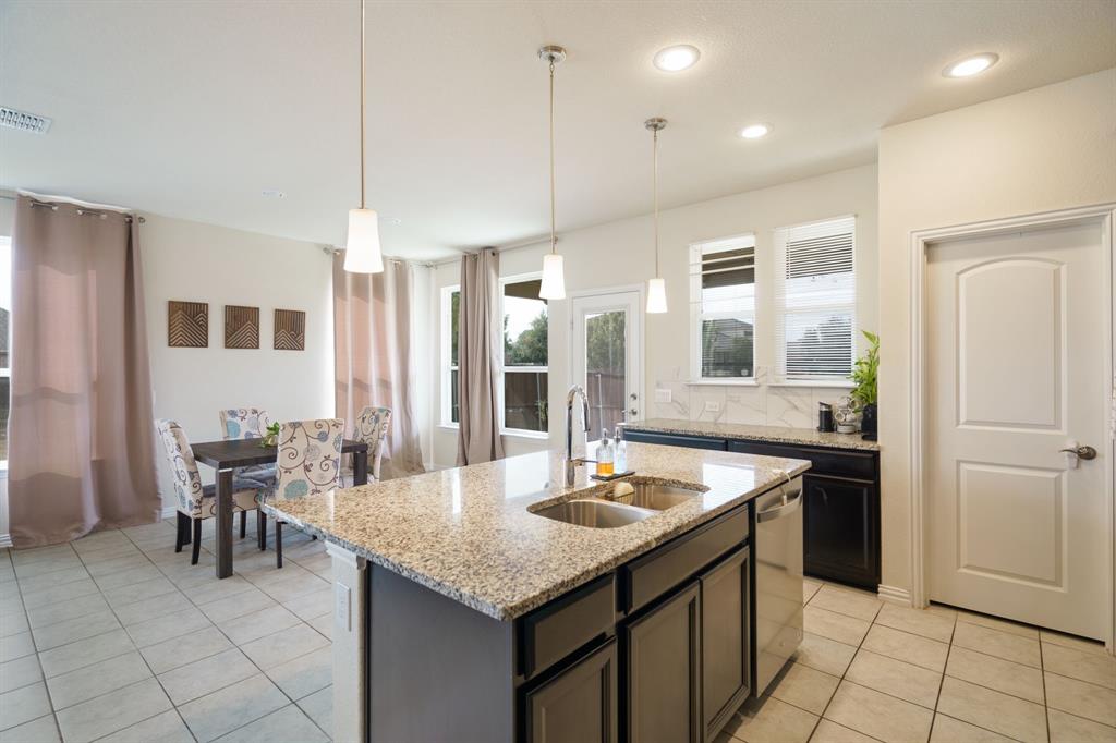 6049 Iron Creek Road Fort Worth, TX 76137 - Photo 12 of 30 a kitchen with center island and stainless steel appliances