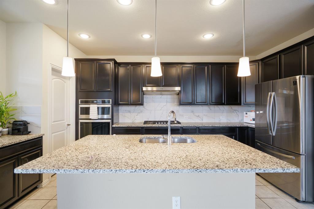 6049 Iron Creek Road Fort Worth, TX 76137 - Photo 13 of 30 a kitchen with stainless steel appliances granite countertop a sink and a refrigerator