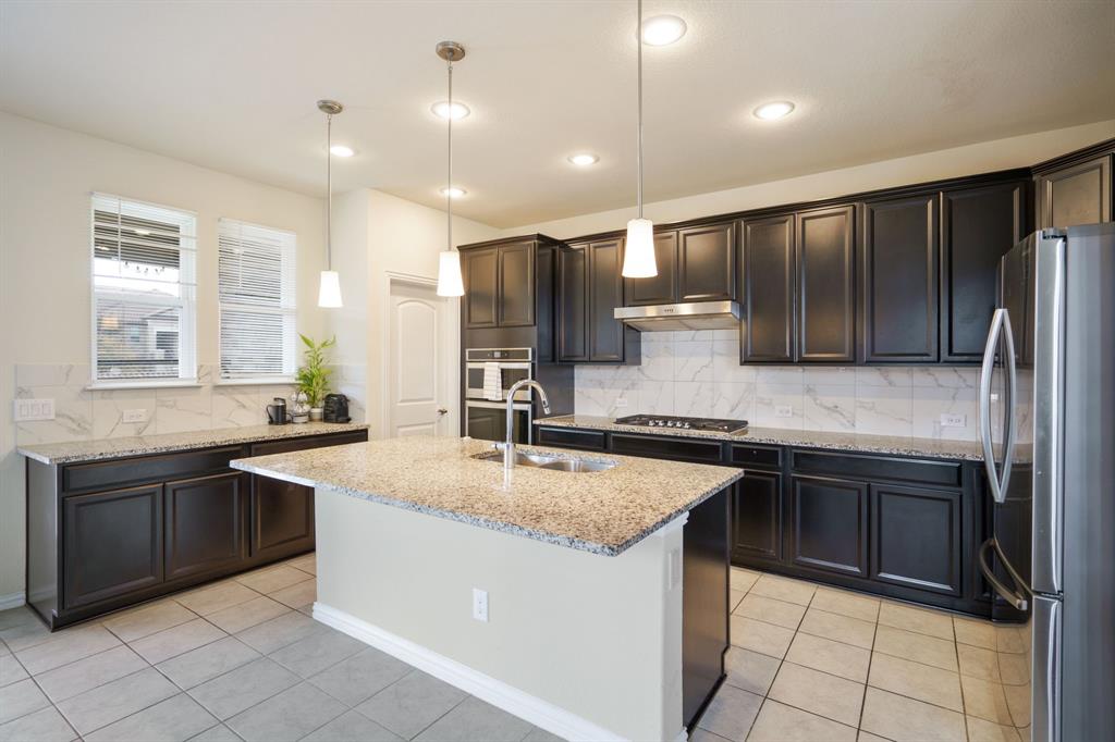 6049 Iron Creek Road Fort Worth, TX 76137 - Photo 14 of 30 a kitchen with stainless steel appliances granite countertop a sink stove and refrigerator