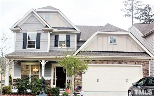 a view of a white house with large windows and a small yard