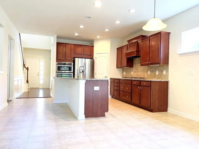a kitchen with stainless steel appliances granite countertop a refrigerator and a sink