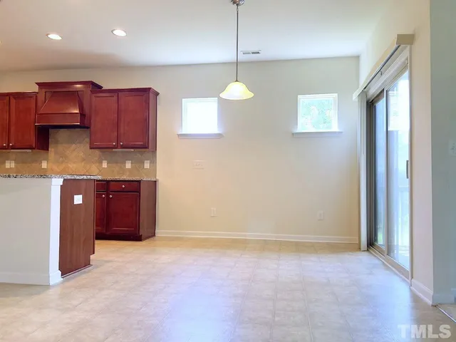 a kitchen with kitchen island granite countertop a stove a sink and a refrigerator with wooden floor