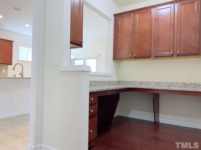 a kitchen with granite countertop a sink cabinets and wooden floor