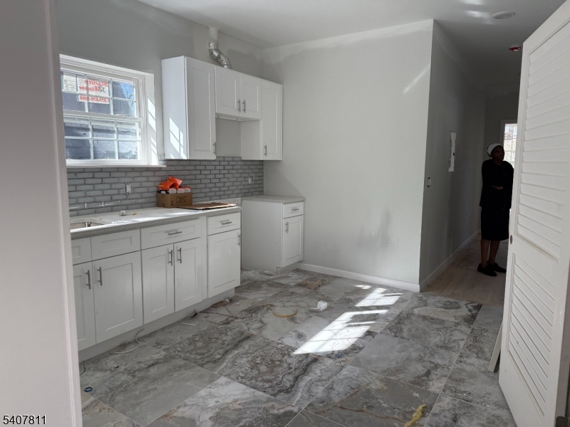357 South 11th Street, Unit 3 Newark, NJ 07103 - Photo 13 of 13 a kitchen with white cabinets a sink and dishwasher