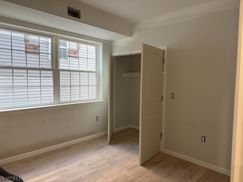 357 South 11th Street, Unit 3 Newark, NJ 07103 - Photo 8 of 13 a view of an empty room with wooden floor and a window
