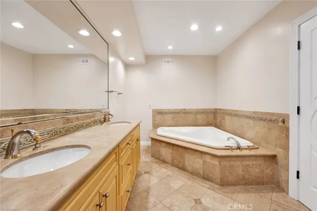 a bathroom with a granite countertop sink a toilet and a tub