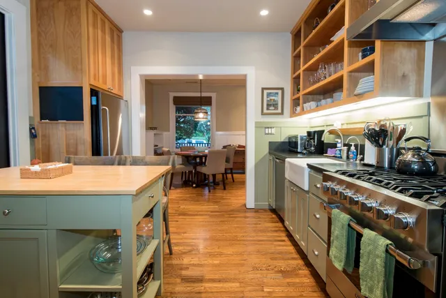 a kitchen with stainless steel appliances granite countertop a stove and a dining table