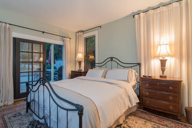 a bedroom with a bed a mirror and a window