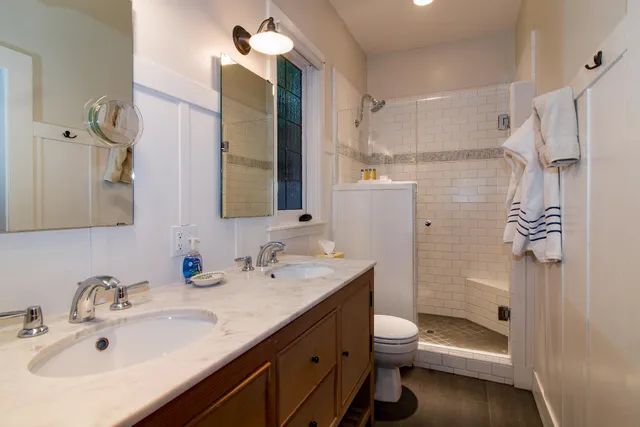 a bathroom with a granite countertop sink toilet and shower